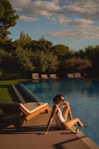 索林索罗那宫酒店的坐在游泳池旁的身着白色衣服的女人