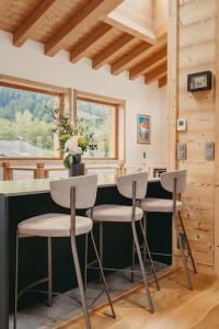 夏蒙尼-勃朗峰Chalet Isabella : cozy & comfy in central Chamonix的小屋内的厨房,在柜台处设有两张凳子