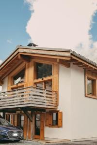 夏蒙尼-勃朗峰Chalet Isabella : cozy & comfy in central Chamonix的带阳台的房子和门前的停车位