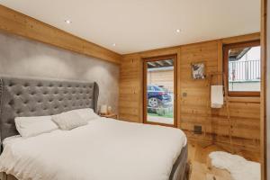 夏蒙尼-勃朗峰Chalet Isabella : cozy & comfy in central Chamonix的一间卧室设有一张大床和木墙