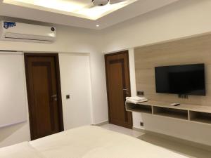 卡拉奇Hamsun Apart Hotel Clifton的卧室配有壁挂式平面电视