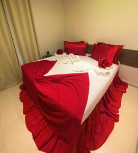 福塔莱萨Angra Praia Hotel的一张大床,配有红色和白色的床单和红色枕头