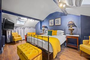 约克The Fat Badger York的蓝色和黄色的卧室设有床和电视