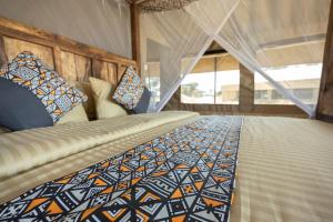 SinoniAfrica Safari South Serengeti Ndutu Ngorongoro的一间卧室配有一张床和被子