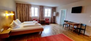 多瑙河畔克雷姆斯Wirtshaus Leindl的配有一张床和一张书桌的酒店客房