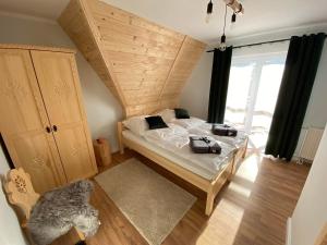 斯派特克维瑟Willa Pod Wyciągiem的一间卧室设有一张木天花板床。