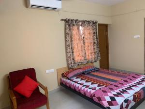 哥印拜陀Sunil Residency的卧室配有床、椅子和窗户。