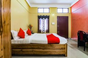 BhutiāgāonOYO Alohi Ghar的一间卧室配有一张带红色枕头的大床