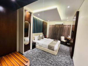 巴纳内拉斯Richmond Hotel Sylhet的配有一张床和一张书桌的酒店客房