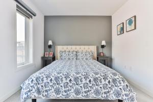 多伦多3bdr townhouse in Downsview Park - Free parking - 25 min to Downtown的一间卧室配有一张带蓝色和白色床单的床。
