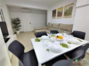 加的斯Gades Natura Apartment a 450 mts Victoria beach的客厅配有白色的桌椅