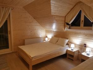 BorzontCabana Katica 2 vendégház的木制客房内的一间卧室,配有一张床