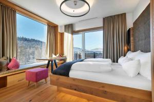 博登迈斯Resort Hotel的一间卧室设有一张大床和一个大窗户