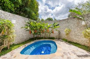 拉罗马纳Casa de Campo Luxury Villas - Private Paradise at La Romana的后院的游泳池,有砖墙