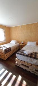 纳塔列斯港Cabañas Sierra Dorotea的卧室设有两张床,铺有木地板,设有窗户。