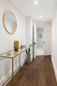 伦敦Luxury Chelsea Flat的走廊上设有桌子和镜子