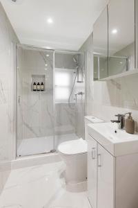 伦敦Luxury Chelsea Flat的带淋浴、卫生间和盥洗盆的白色浴室