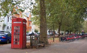 伦敦Luxury Chelsea Flat的一辆停放自行车旁边的红色电话亭