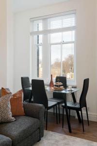 伦敦Luxury Chelsea Flat的一间带桌椅和窗户的用餐室