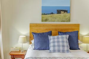 约翰内斯堡The Ashford的一间卧室配有一张带蓝色和白色枕头的床