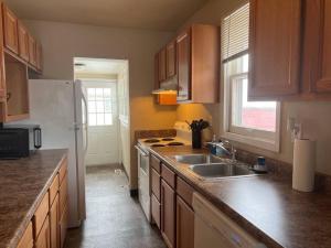 比林斯Classic home on a quiet street的厨房配有木制橱柜、水槽和冰箱。