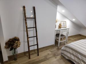 维戈Casa Jardin Vigo的卧室设有桌子旁边的梯子