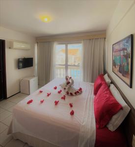 福塔莱萨阿尔加维海滩公寓的酒店客房的床铺上摆放着玫瑰花