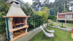 维戈Casa Jardin Vigo的后院配有燃木烤炉和两把椅子