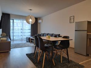 帕扎尔吉克City Apartments 2的厨房以及带桌椅的起居室。