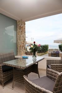 伊拉克里萨Steleni Seaside Apartments的一间设有玻璃桌和椅子的用餐室