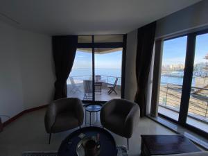 圣保罗湾城Luxury Bay View 3 Bed 3 Bath Seafront Apartment in St Paul's Bay的客厅配有椅子,享有海景