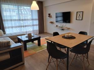 帕扎尔吉克City Apartments 1的客厅配有桌椅和电视。