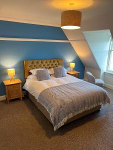 CorrieThe Corrie Hotel的一间卧室设有一张蓝色墙壁的大床