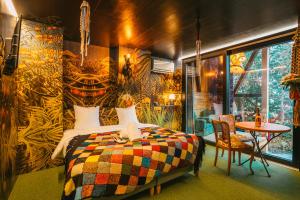 盖布维莱尔Domaine Bohème I art de vivre的一间卧室配有一张带彩色毯子的床