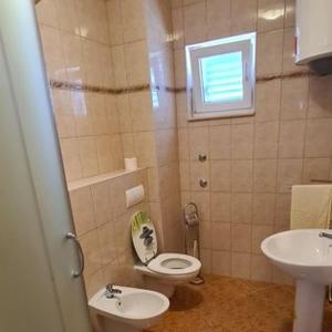 特罗吉尔Apartmani Gizela的一间带卫生间、水槽和窗户的浴室