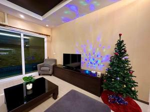 乔木提恩海滩Tinker Bell Pool Villa的客厅配有圣诞树和电视