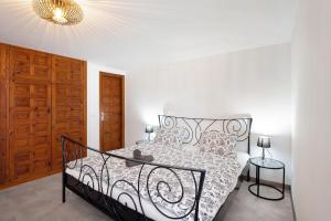 洛斯雷亚莱霍斯Casa Hola Mar的卧室配有黑白床和吊灯。