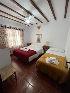 希梅拉德利瓦尔Casa Jara的一间卧室配有两张床和吊扇