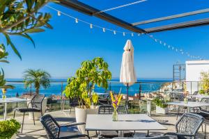 萨各夫雷纳米巴酒店的一个带桌椅的庭院,背景为大海