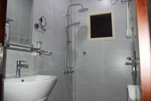 吉赞Delta Hotel Suites的带淋浴、水槽和卫生间的浴室
