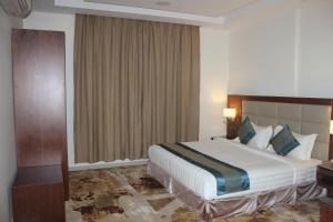 吉赞Delta Hotel Suites的一间设有大床和窗户的酒店客房
