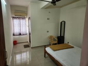 蒂鲁瓦纳马莱Raja Rani Mahal Ac-Rooms的一间卧室配有一张床和一把椅子