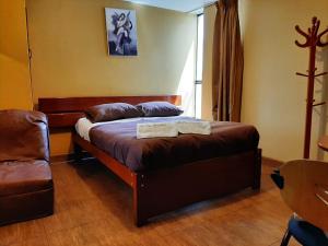 阿亚库乔Hostal Don Cristobal的一间卧室配有一张带椅子的床和一扇窗户