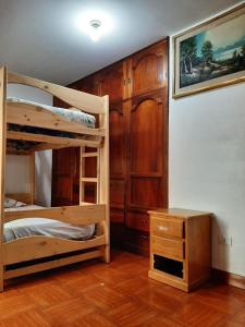 阿亚库乔Hostal Don Cristobal的一间卧室配有两张双层床和一张书桌