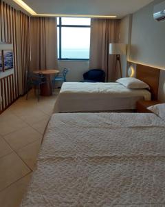 萨尔瓦多Sol Vicitoria Marina的酒店客房设有两张床和一张桌子。
