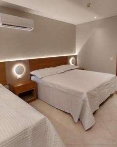 萨尔瓦多Sol Vicitoria Marina的酒店客房配有两张床和风扇