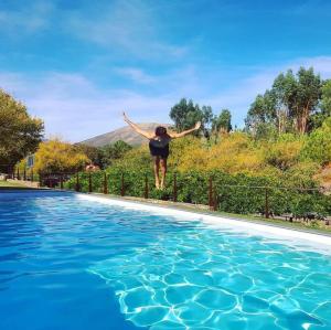 卡什塔涅拉德佩拉Turismo Natureza Villa Rio的跳过游泳池的女人