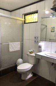 阿拉胡埃拉Brillasol Airport Hotel的一间带卫生间、水槽和镜子的浴室