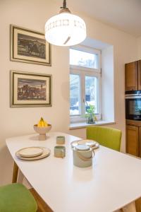 马里博尔Vila Krista的厨房配有白色的桌子和绿色的椅子