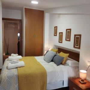 特鲁希略las llaves del arca的一间卧室配有一张大床,提供黄色和蓝色的枕头